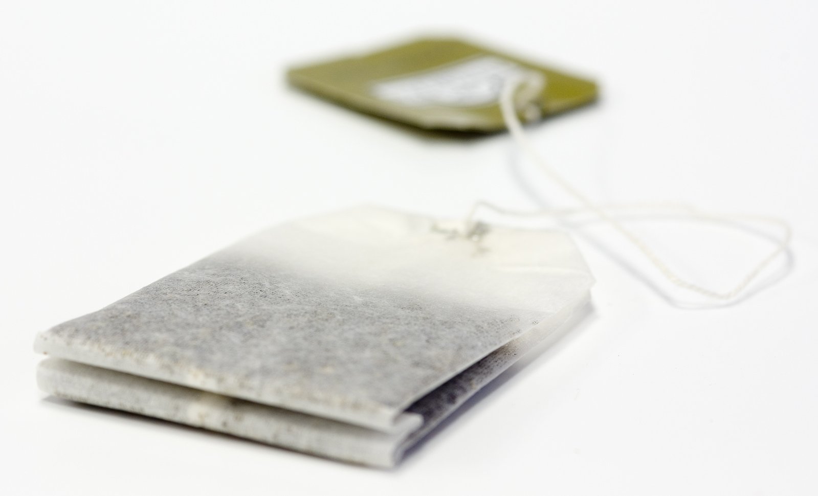 an ipod charger is next to a small, gray piece of material