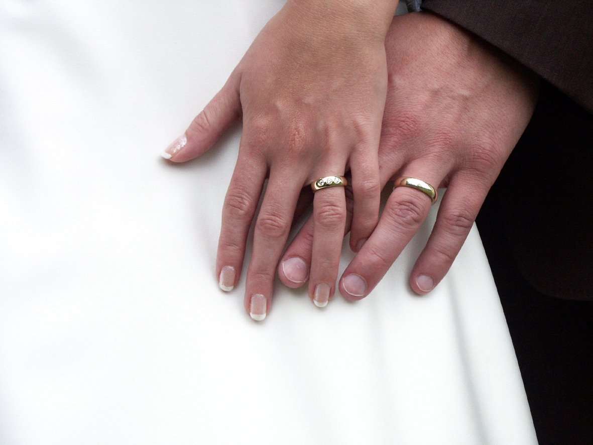a person holding onto another persons hand with their wedding rings on