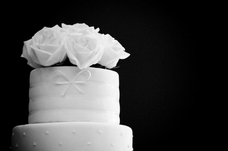 a wedding cake is adorned with two roses