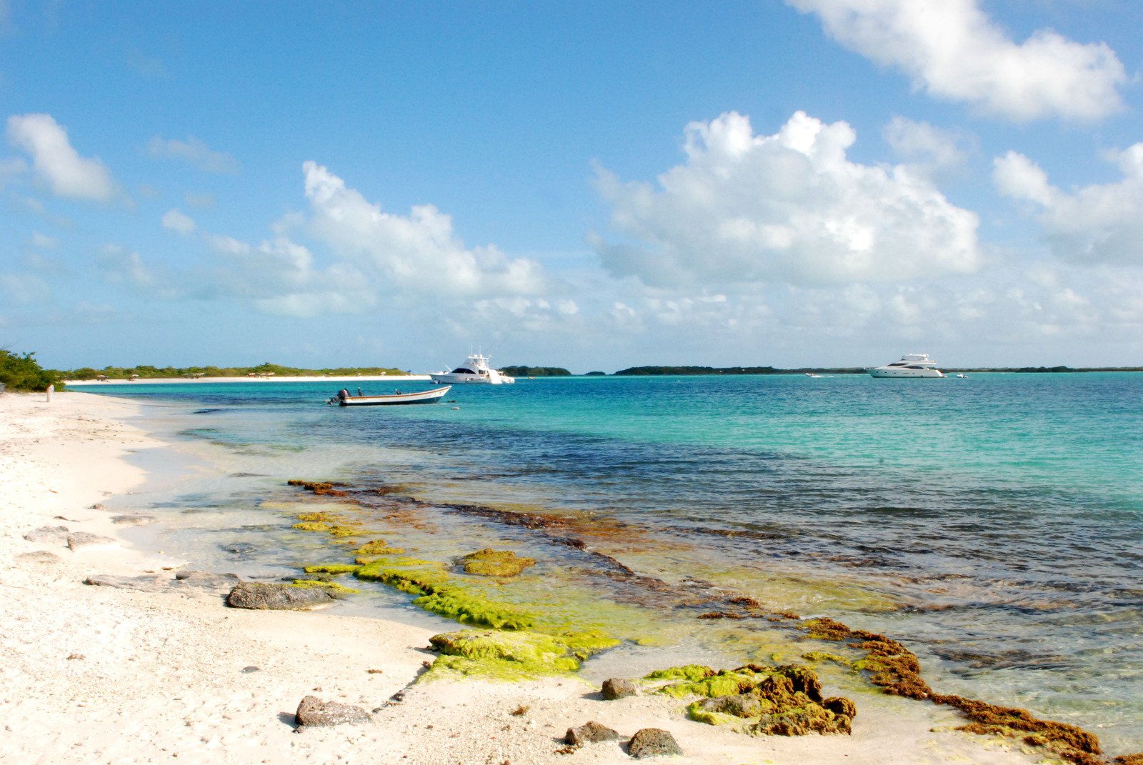 the water is turquoise and there are a few boats