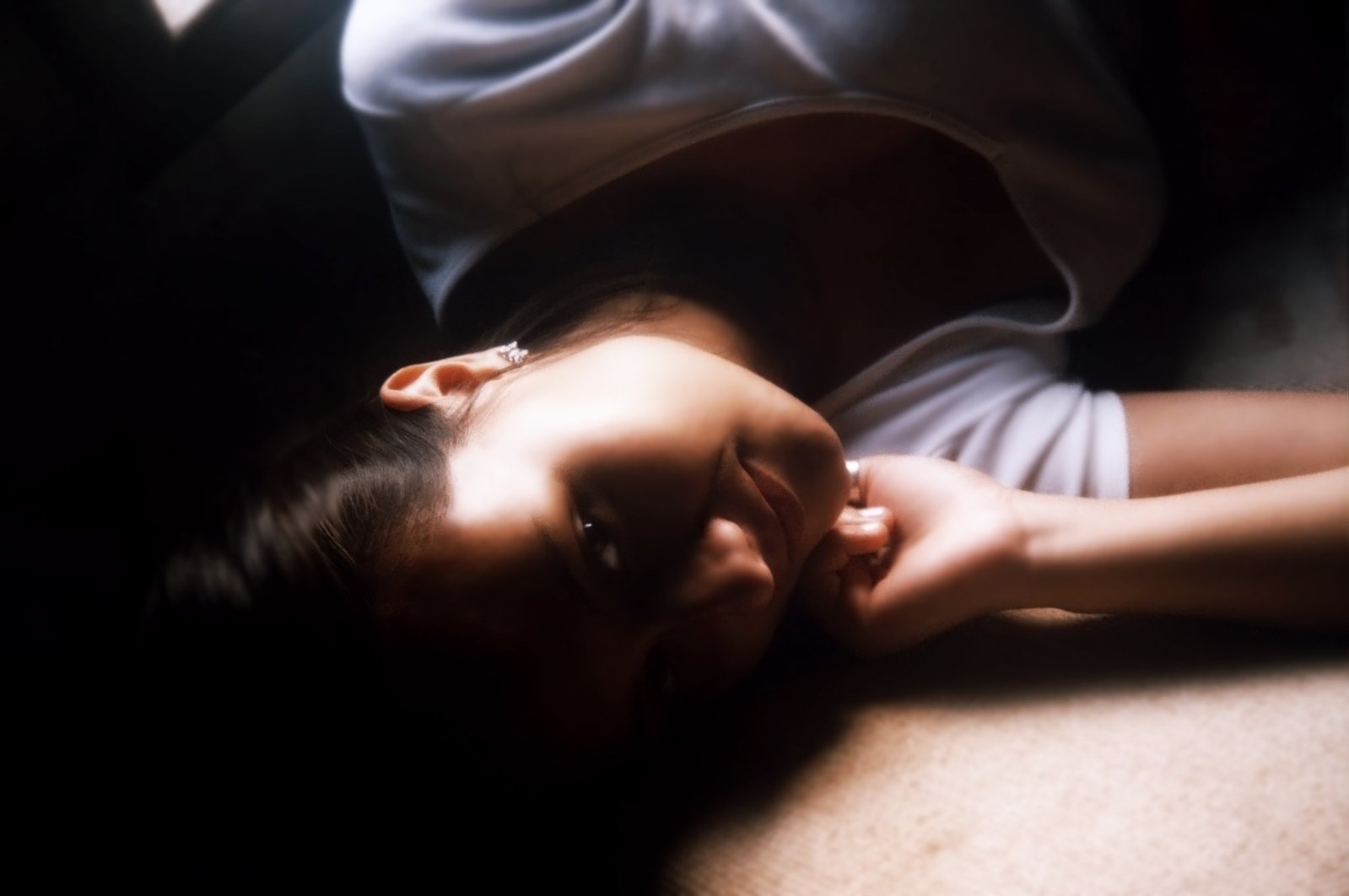 a woman in white shirt laying on the floor