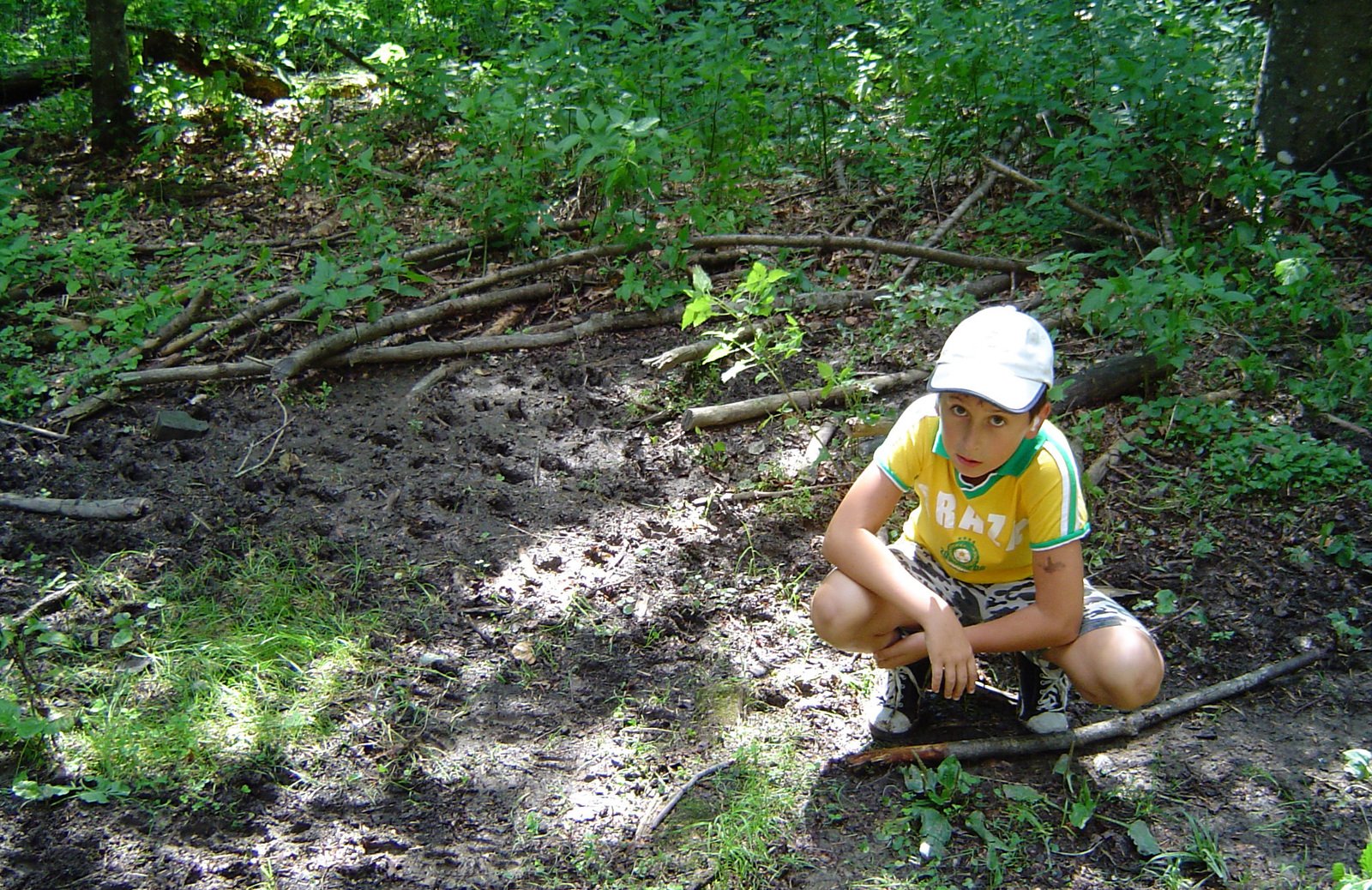 a young child kneeling down in the middle of a forest