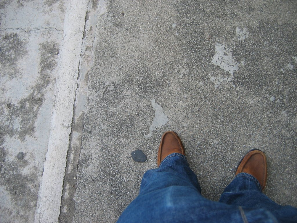 a person standing on the cement looking down