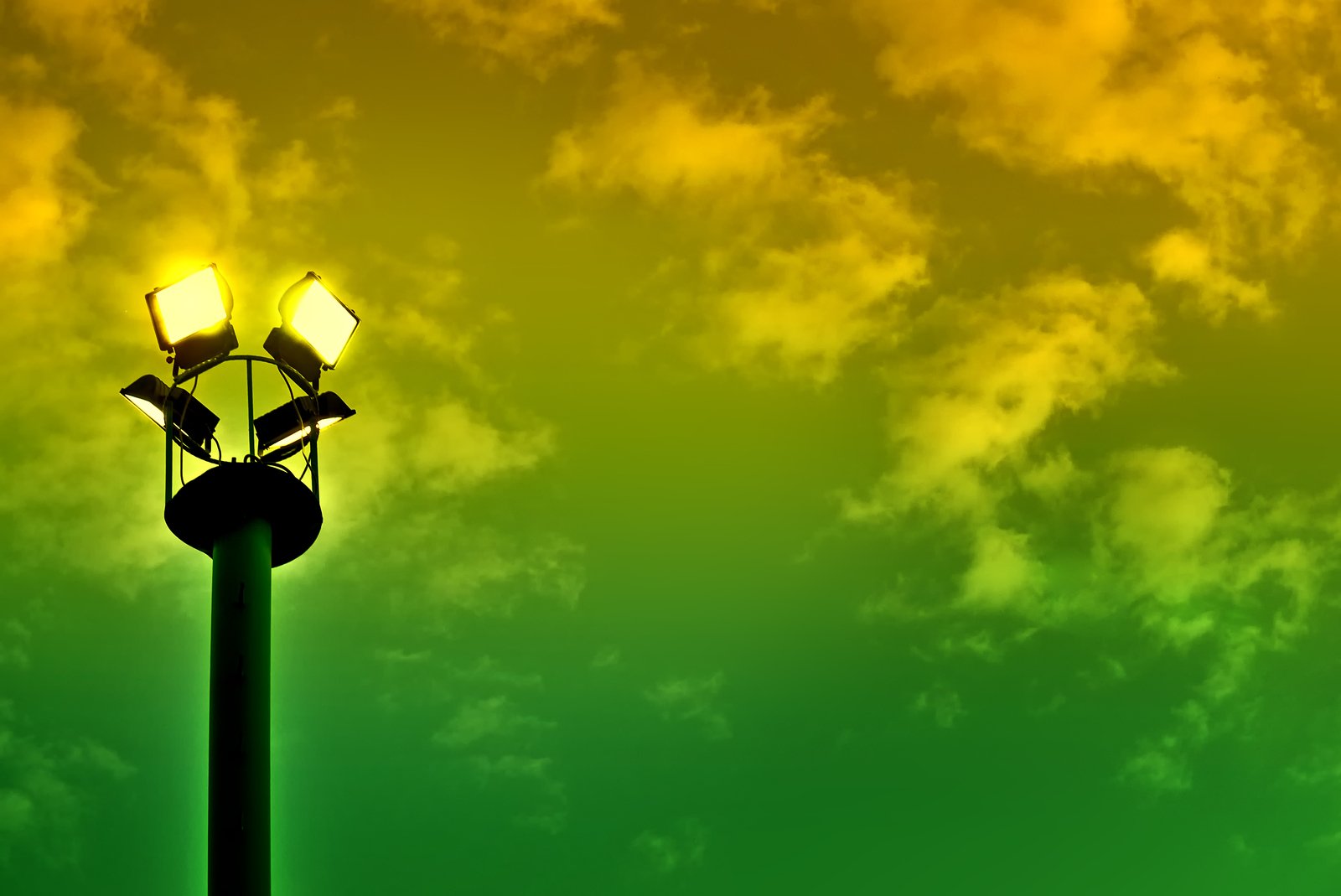 a street light with clouds above it