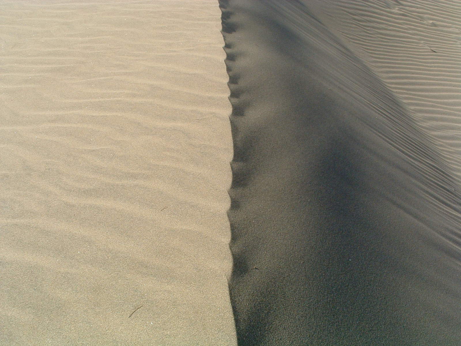 long stripe of black sand in the desert