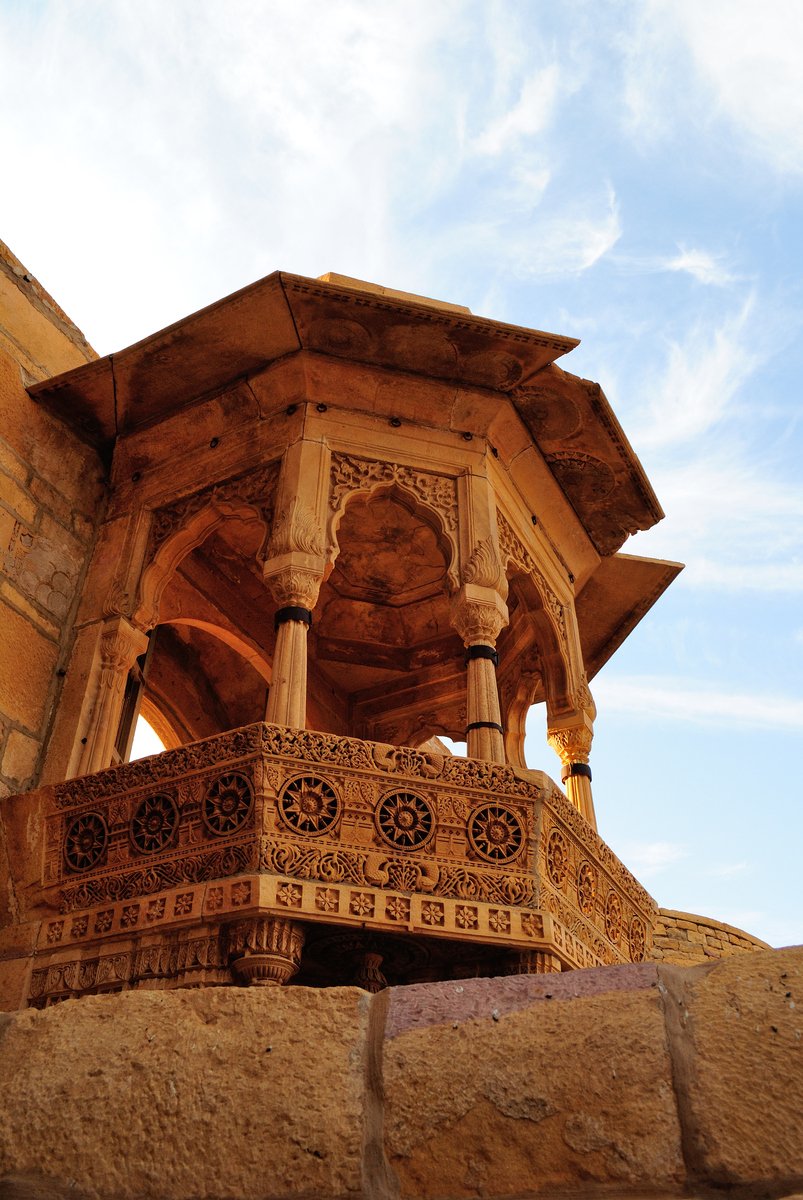 a wooden structure stands on top of a rock