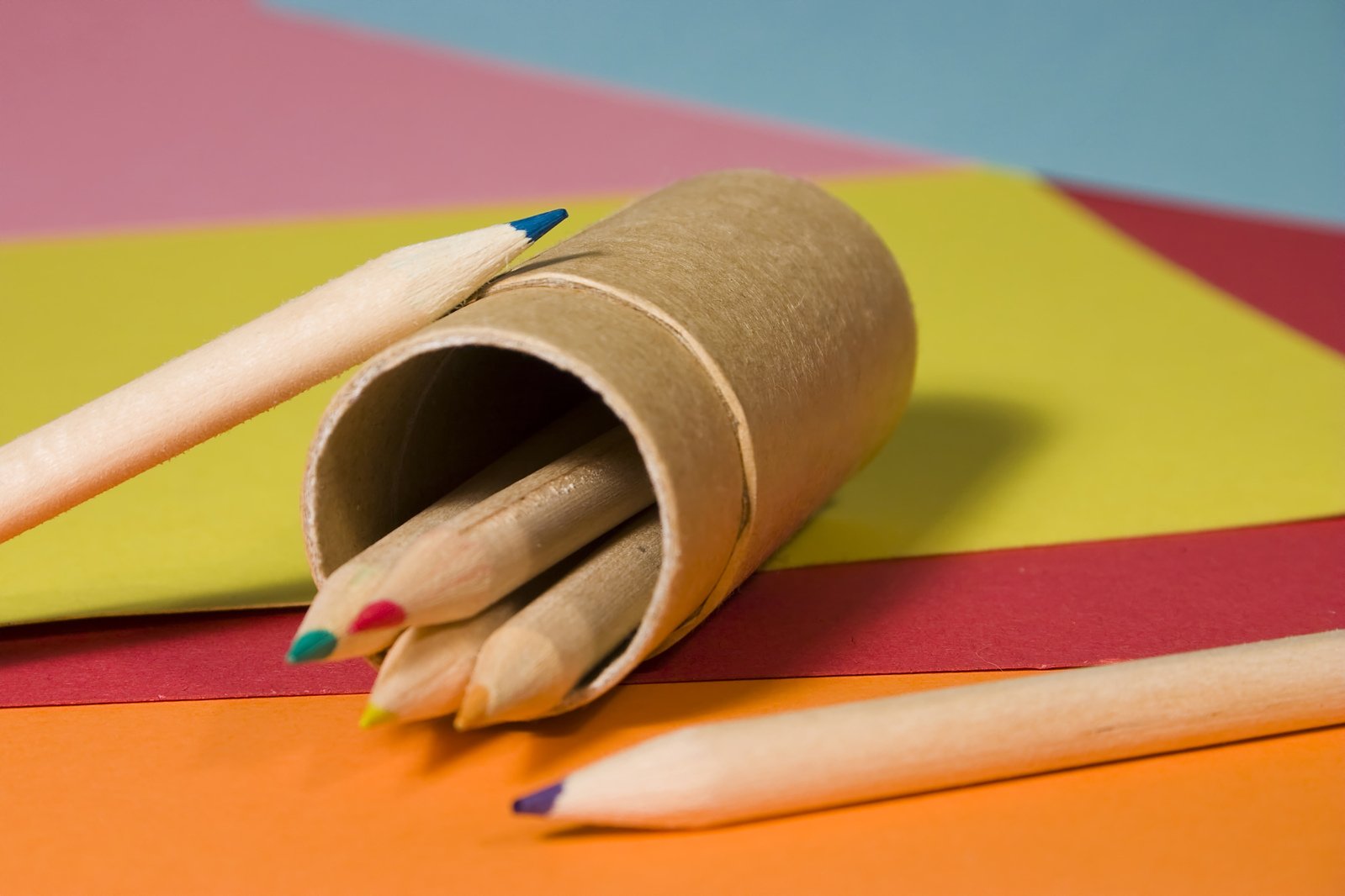 a rolled up cardboard tube with pencils laying on top of it