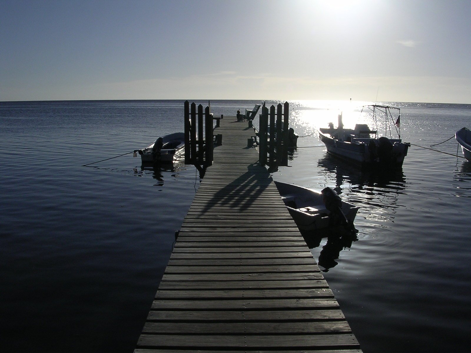 the person is sitting on a boat by the dock