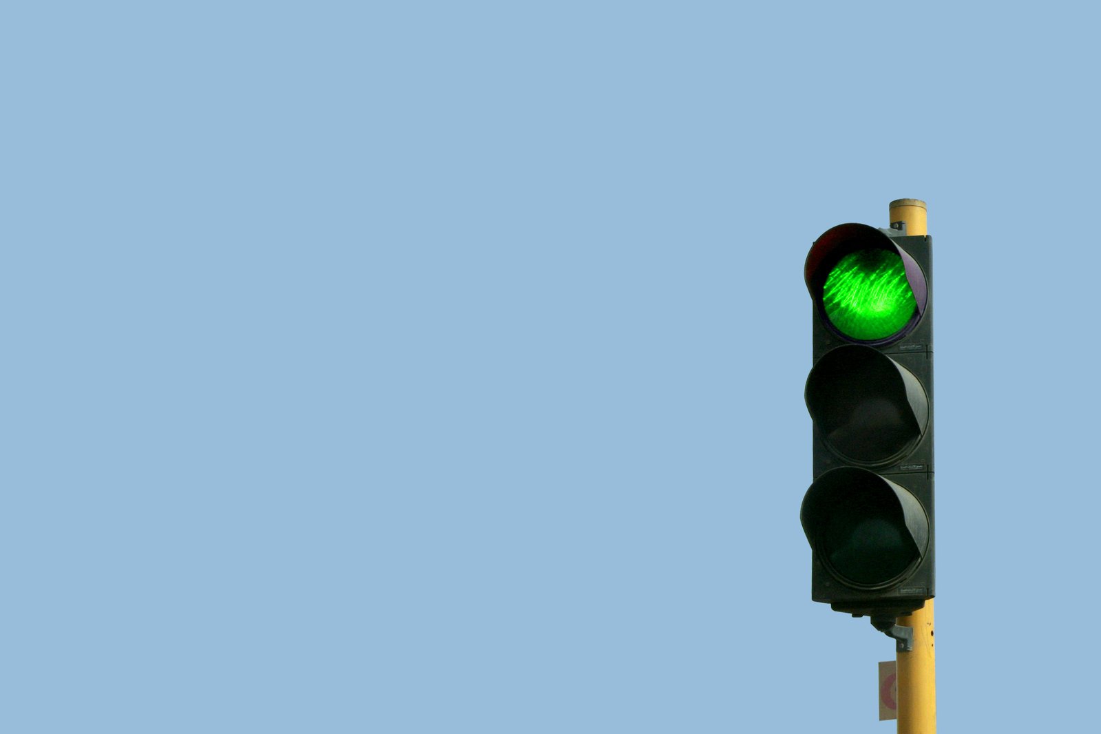 a traffic light with a green street light at the top