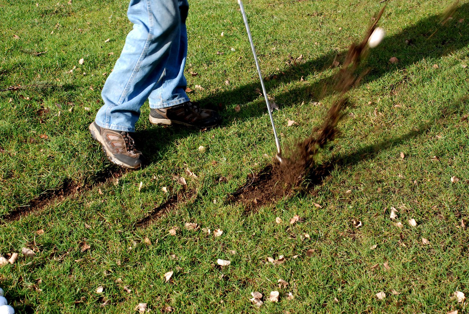 a man hitting a tee ball in the yard