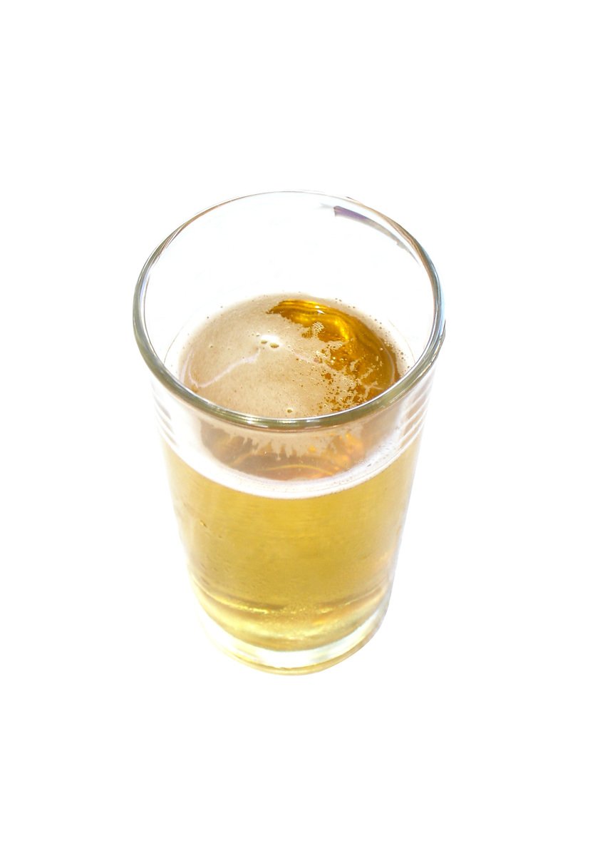 a small glass of beer on a white table