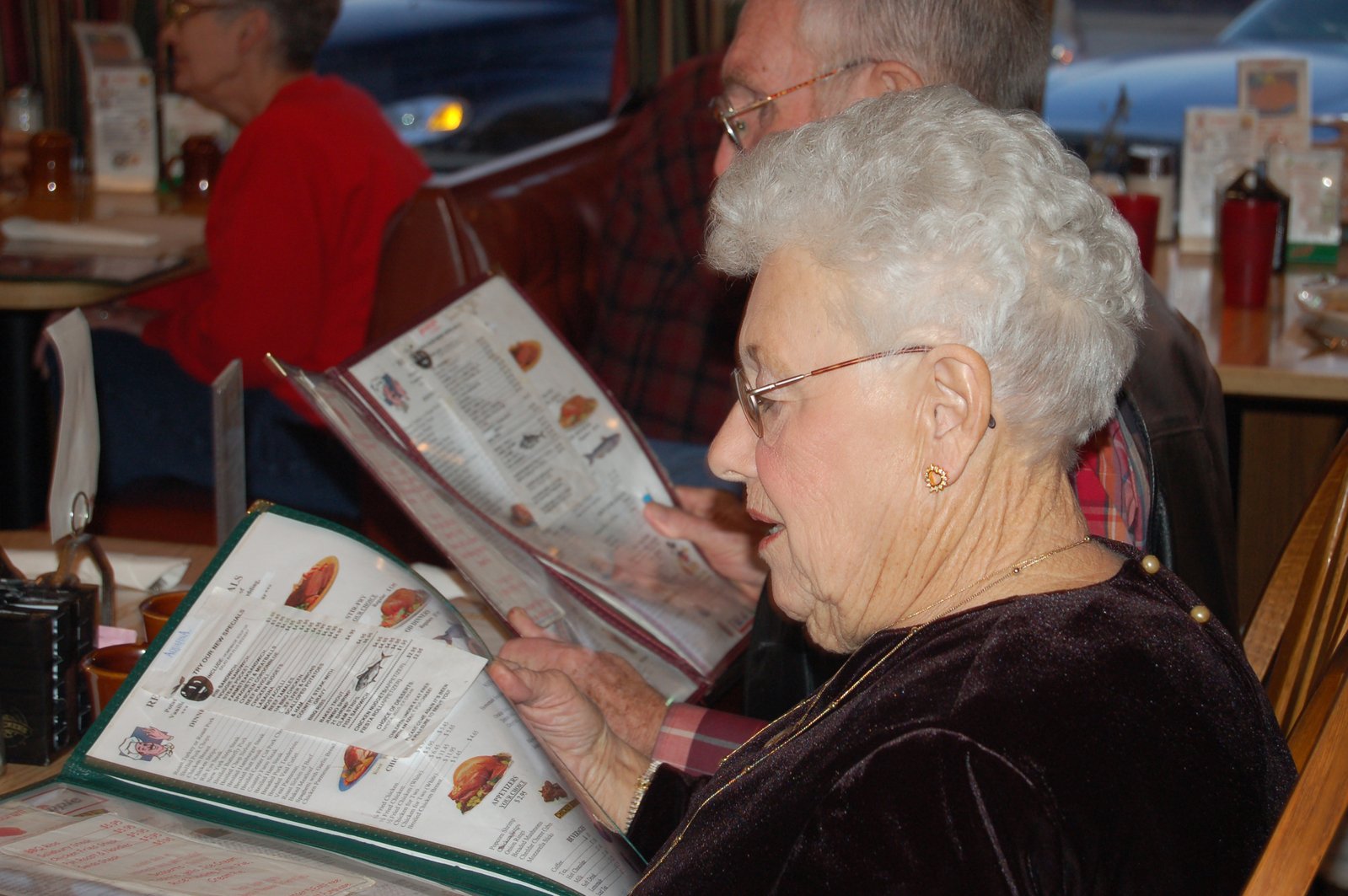 an old lady reading some food in front of another older woman