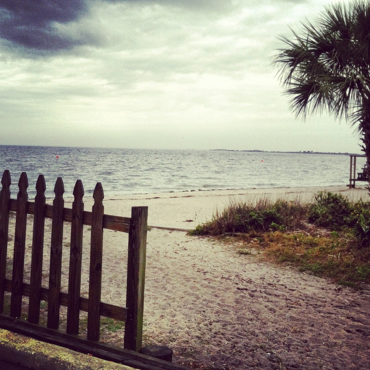 an overcast day and a sandy beach and ocean