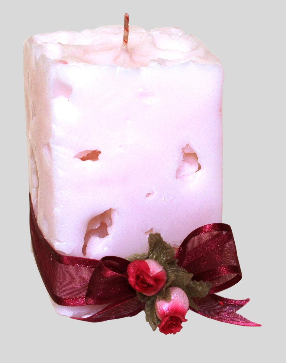 a candle decorated with pink and red ribbon