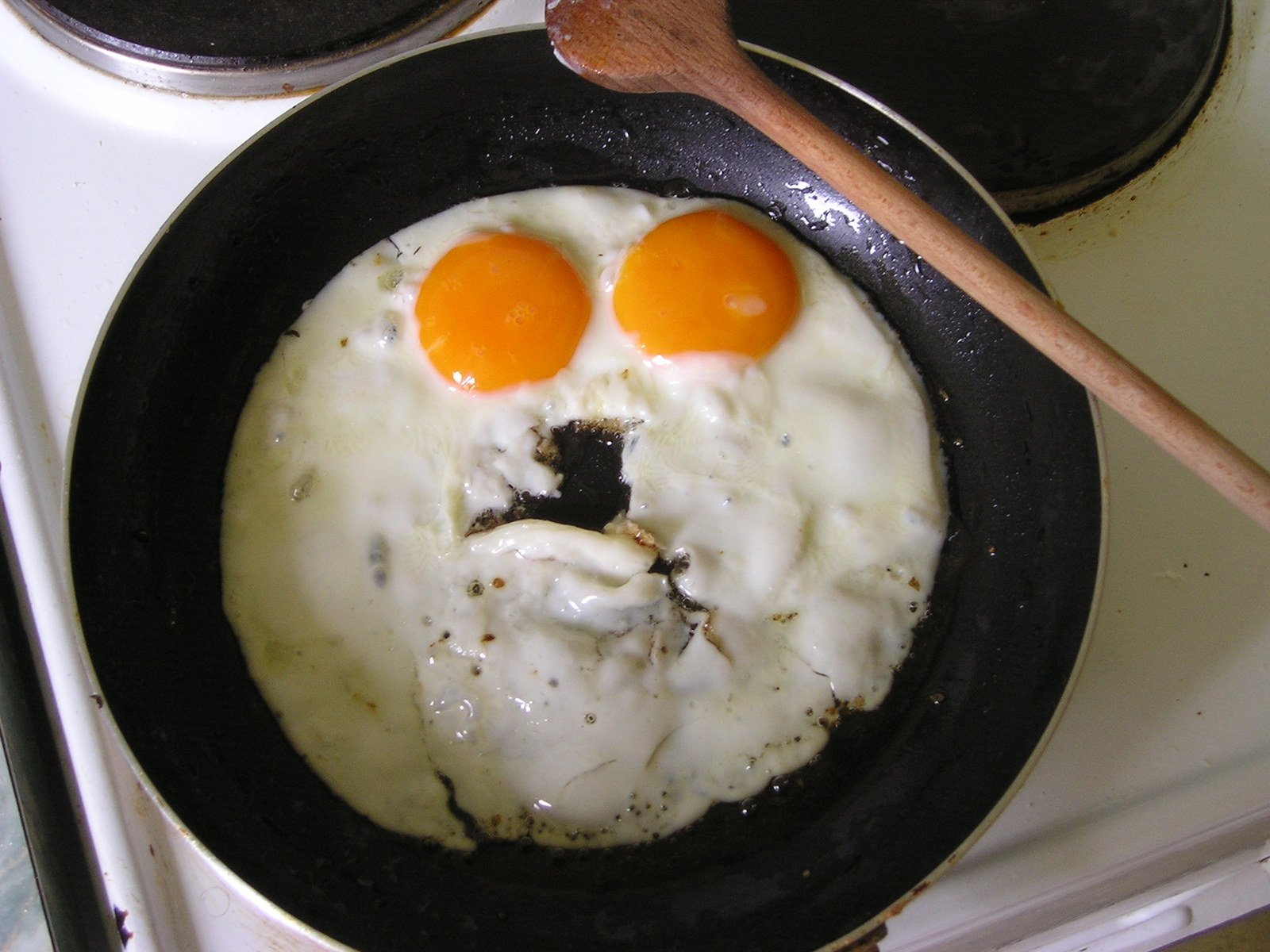 two fried eggs have faces on them in a set