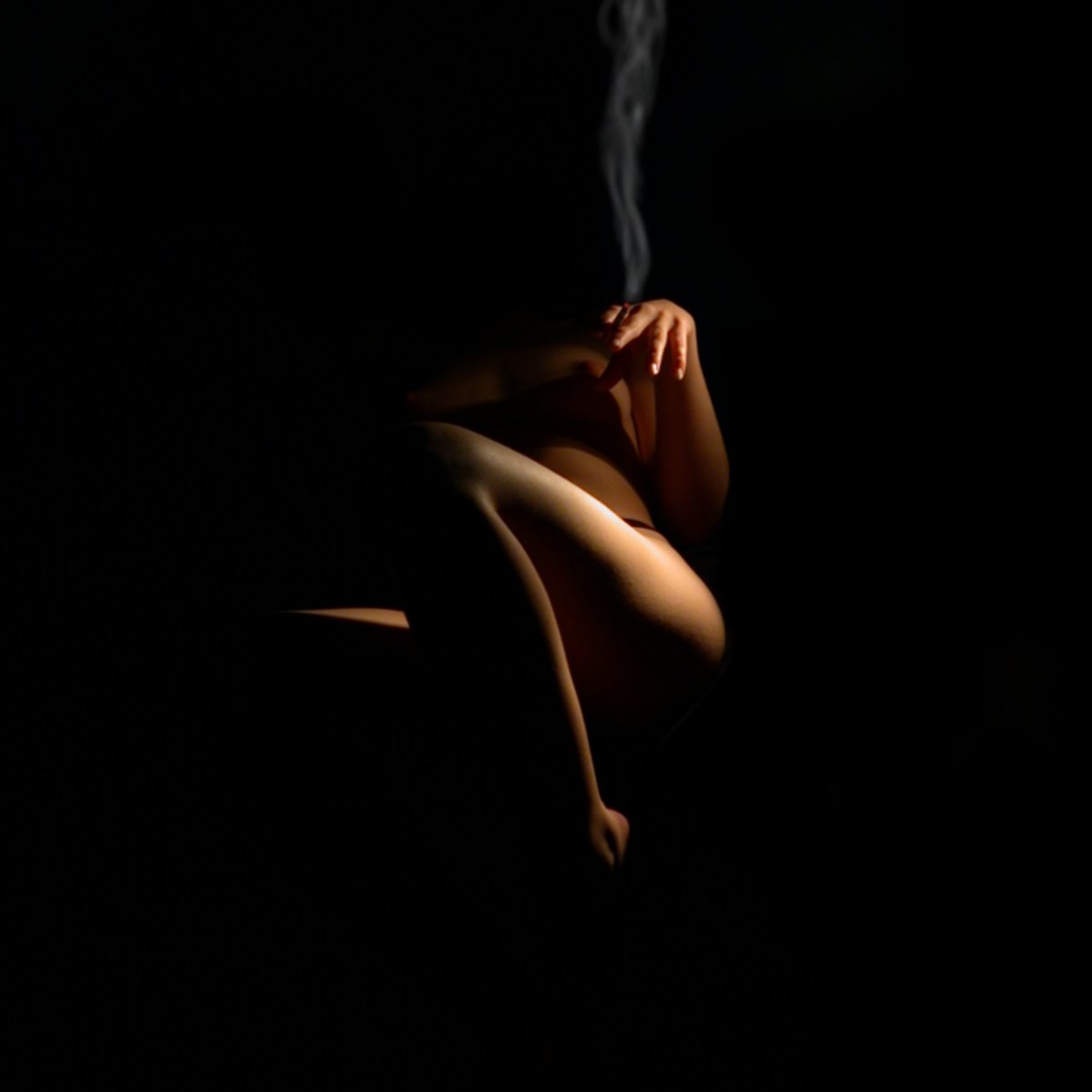  woman smoking a cigarette with dark background