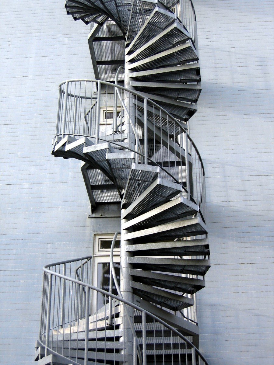 spiral staircases stand in front of an apartment building