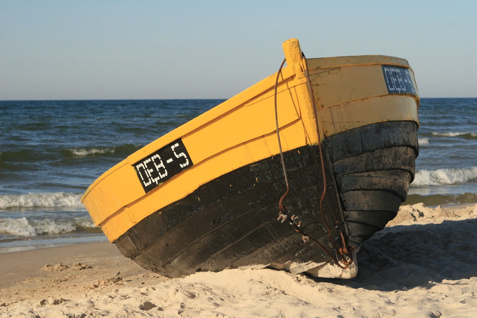 a big yellow and black boat on the shore