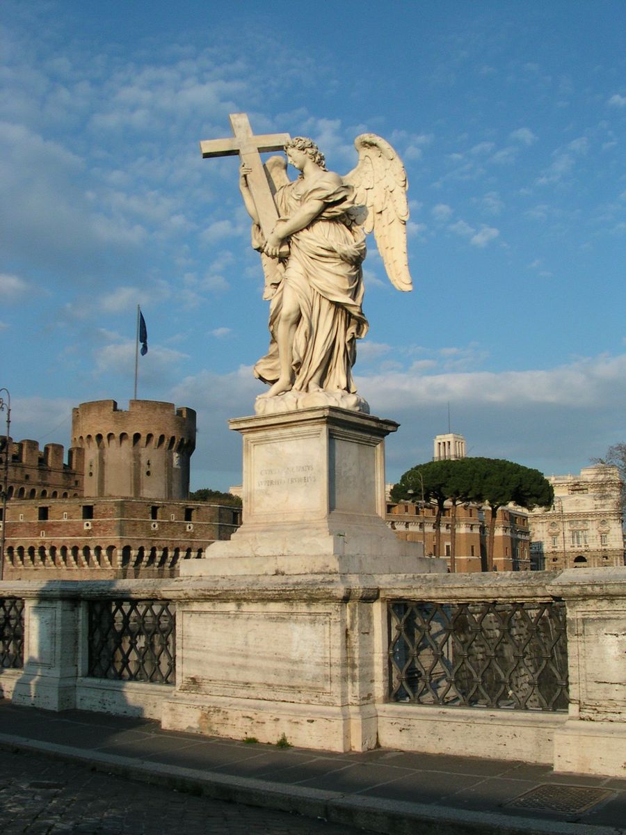 an angel statue in front of a castle