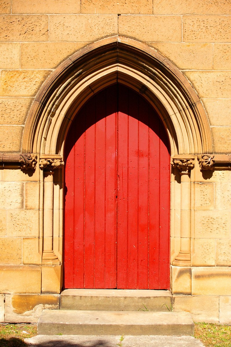 the door to a church with a red door is opened