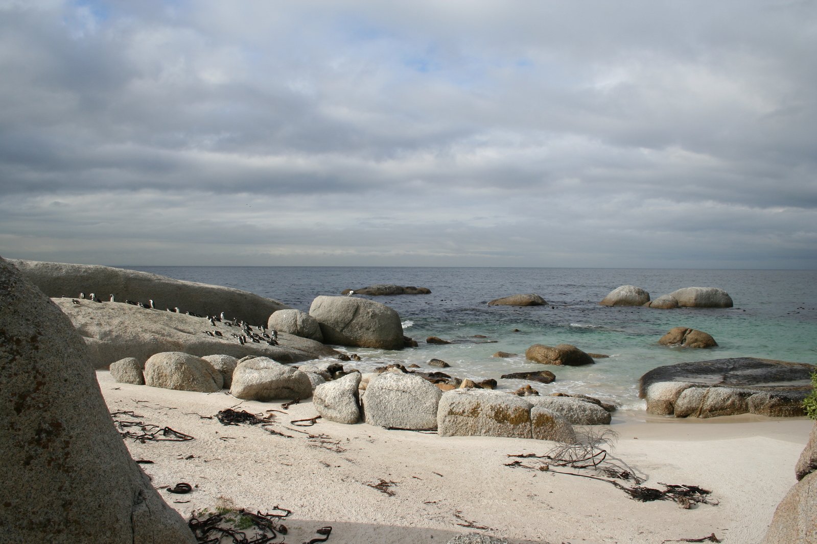 a rocky beach surrounded by water with large rocks