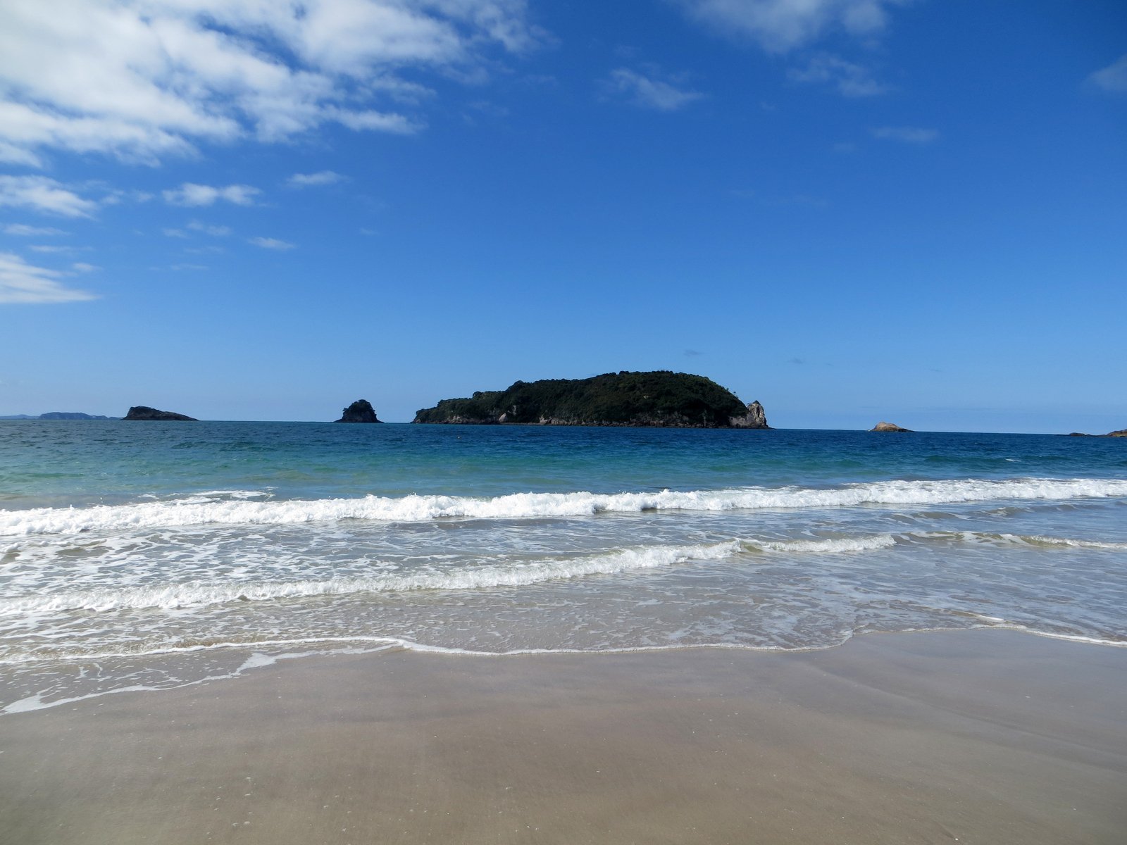 there is a boat out in the ocean at this beach