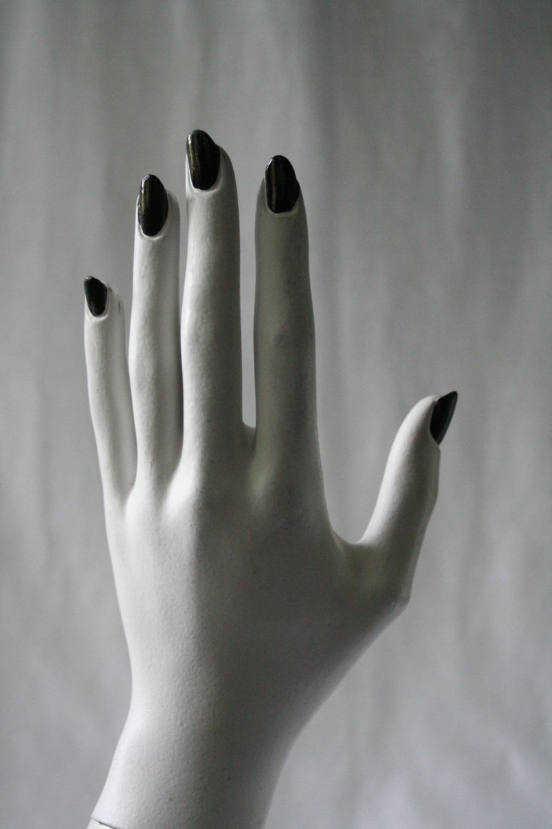 the white sculpture shows several hands on each other