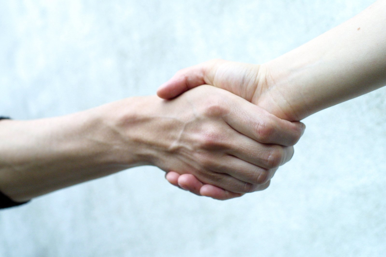 two people who are shaking hands on a piece of paper