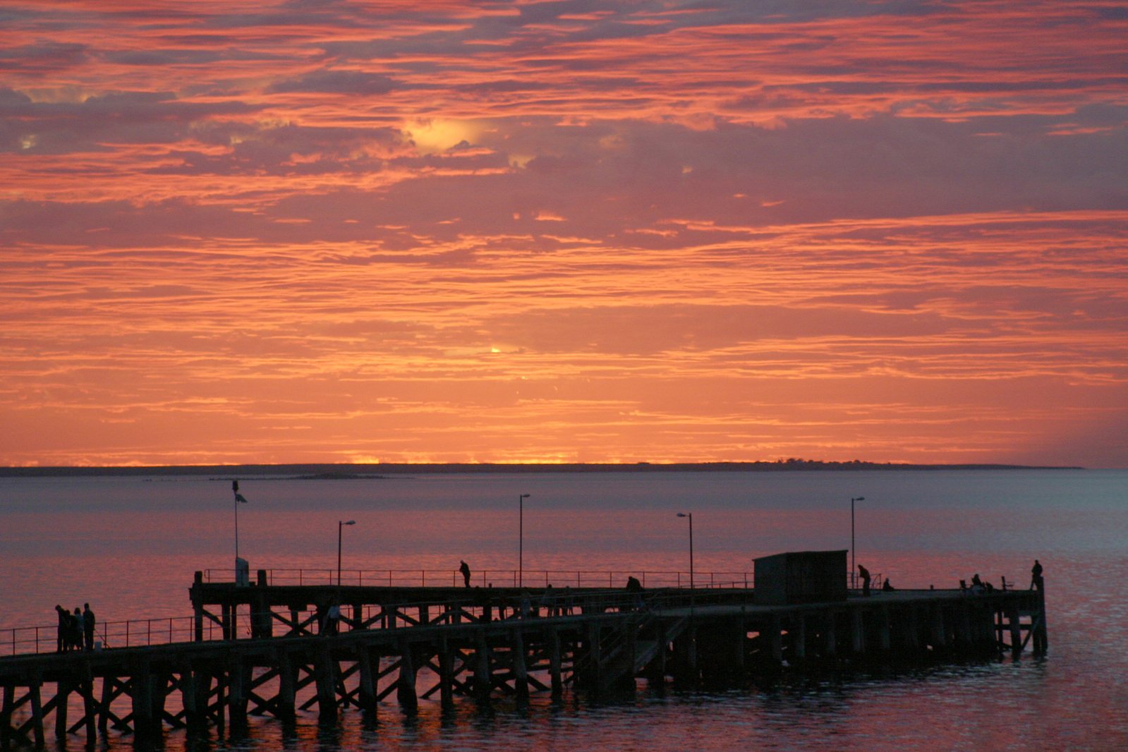 the sun is setting at an empty dock