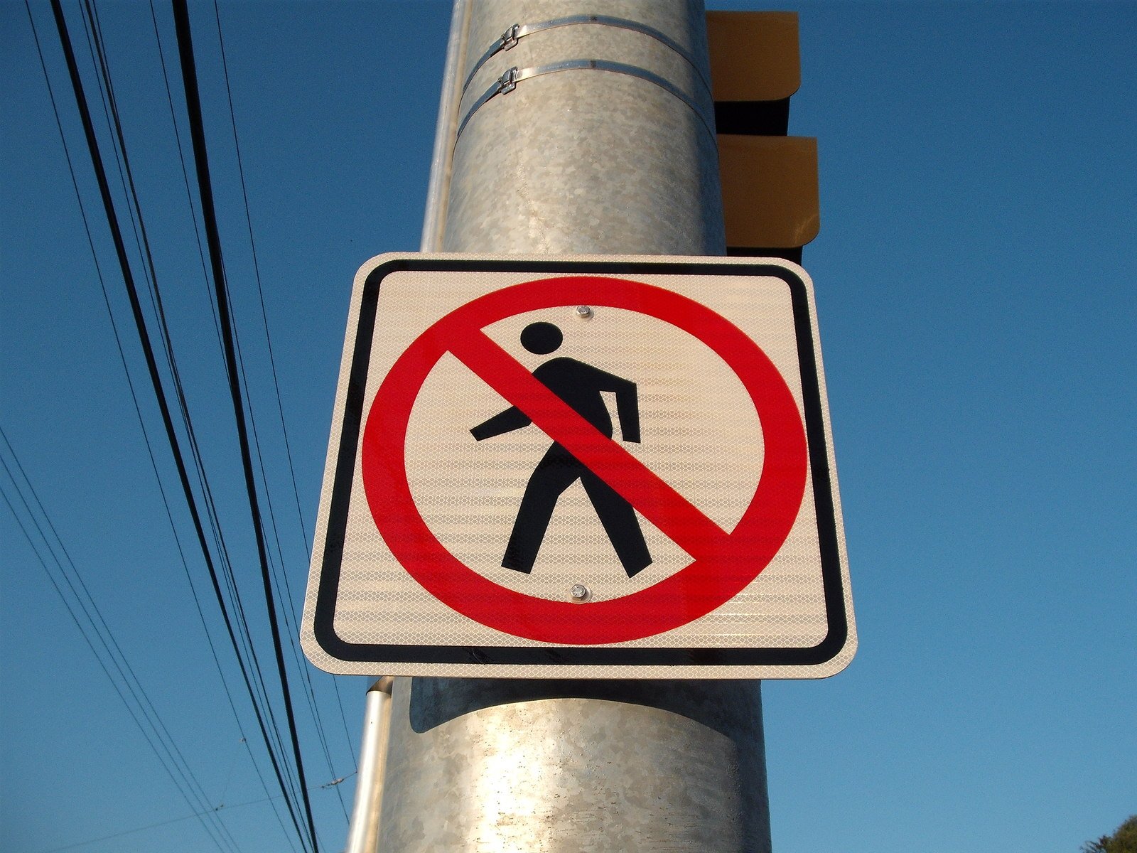 a sign is on a street pole with wires overhead
