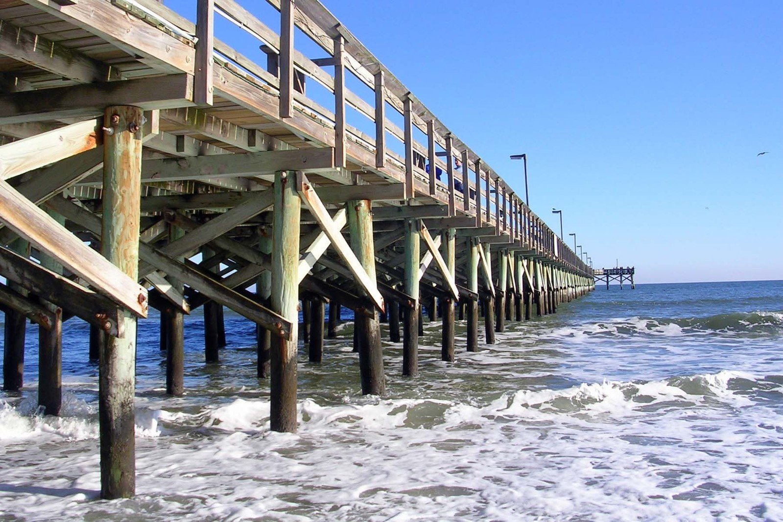 a long pier on the edge of the ocean