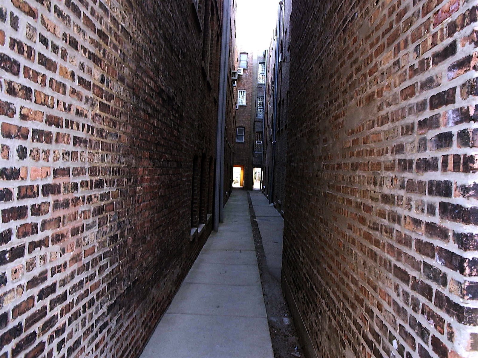 the narrow alley between two buildings has a fire hydrant