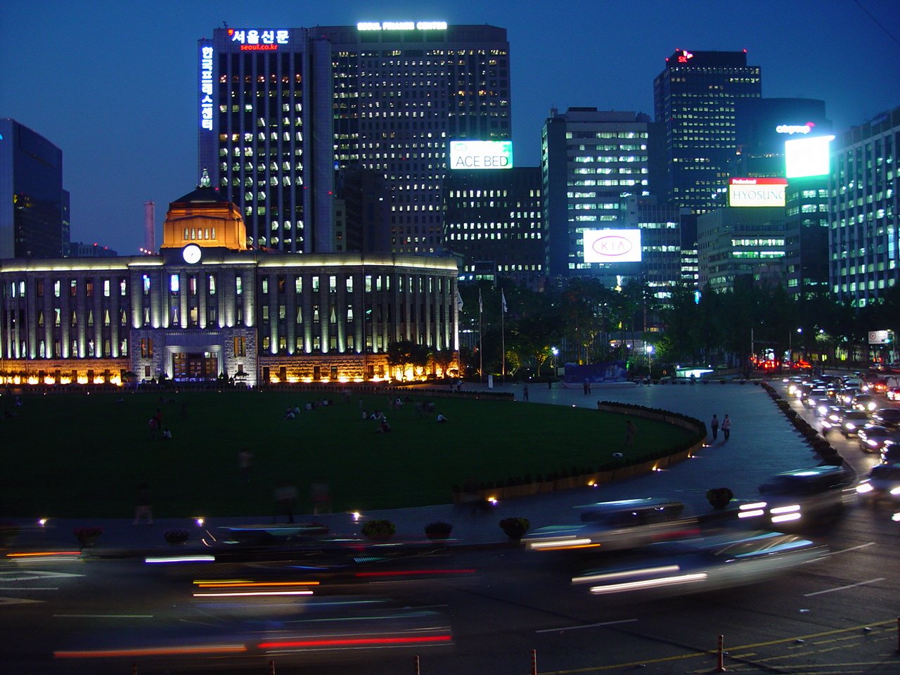 a city in the evening is lit by many streetlights