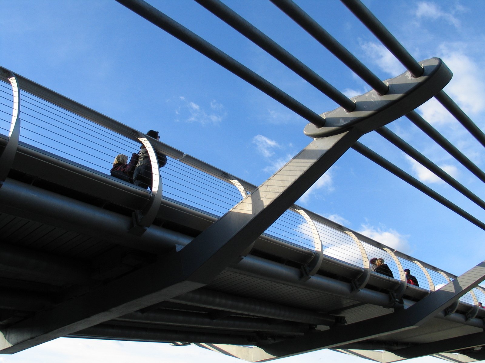 a group of people are walking across the bridge