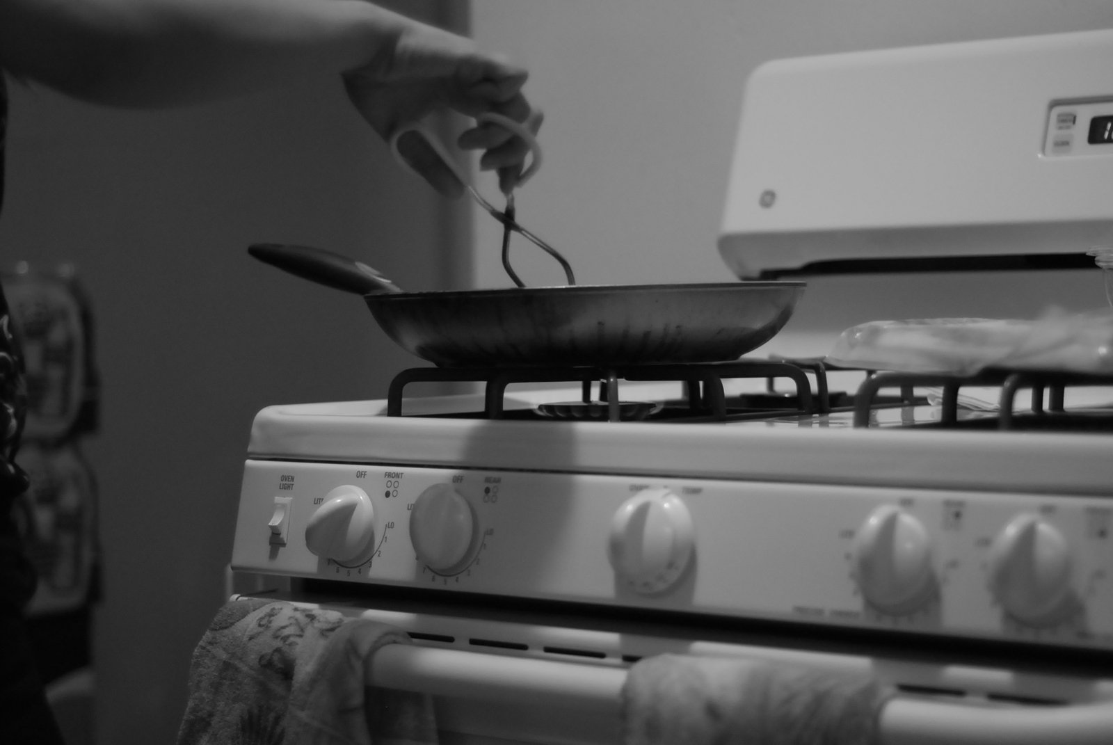 someone cooking food over an open stove top