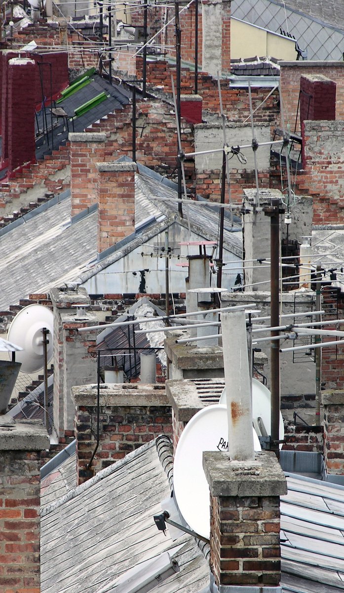 a factory with rooftops of tall buildings in a city