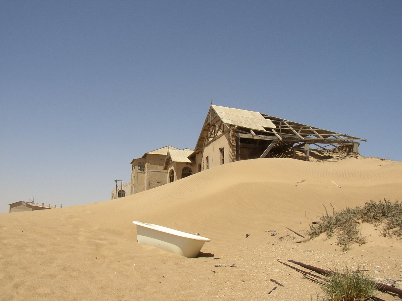 a small boat sitting in the sand outside a hut