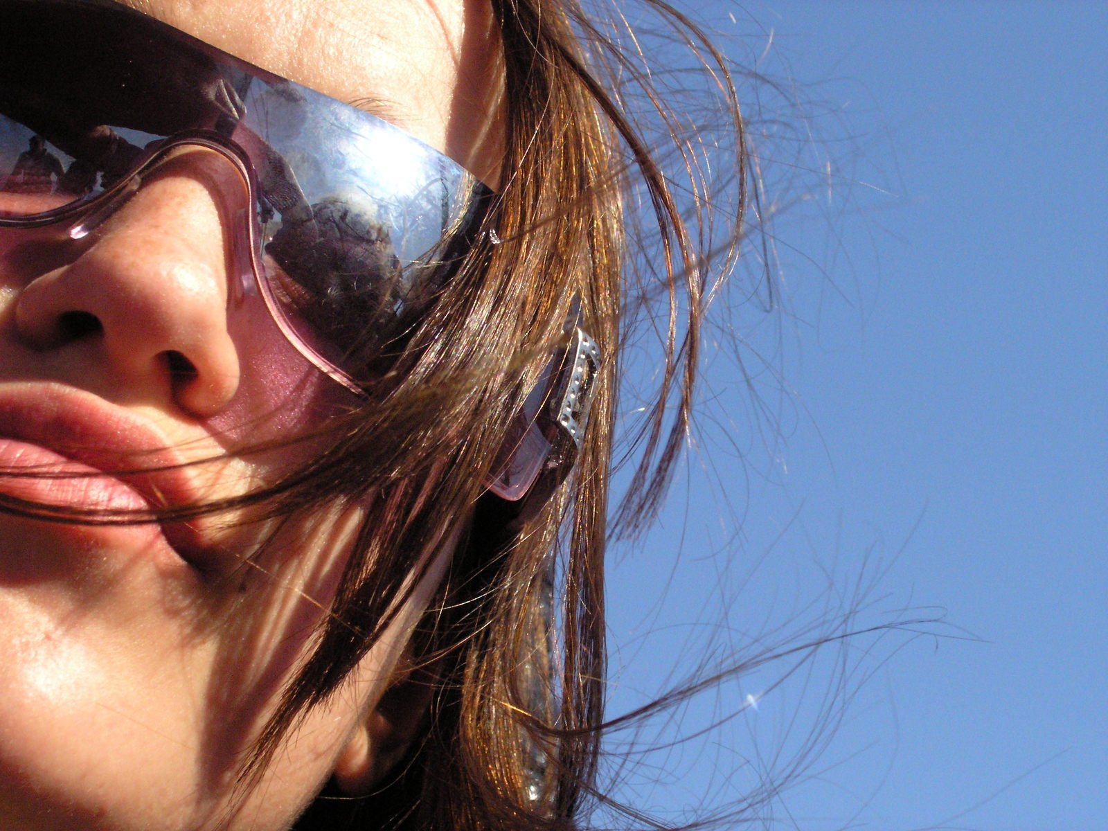 a close up of a woman's face wearing sun glasses
