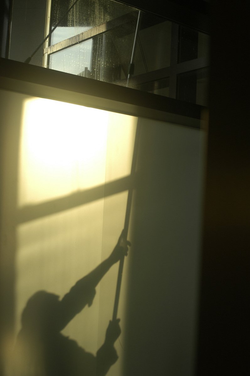 a window with a shadow of a man on the windowsill