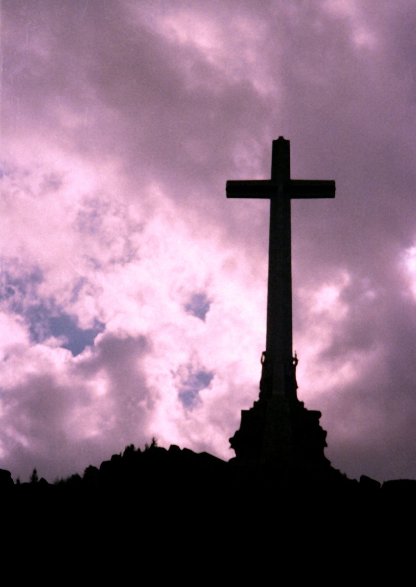 a large cross sitting on top of a hill