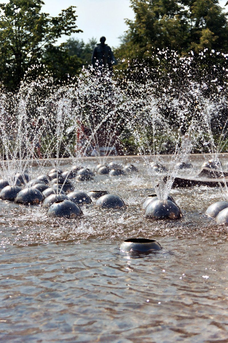 a park with water spraying on it and many rocks on the ground