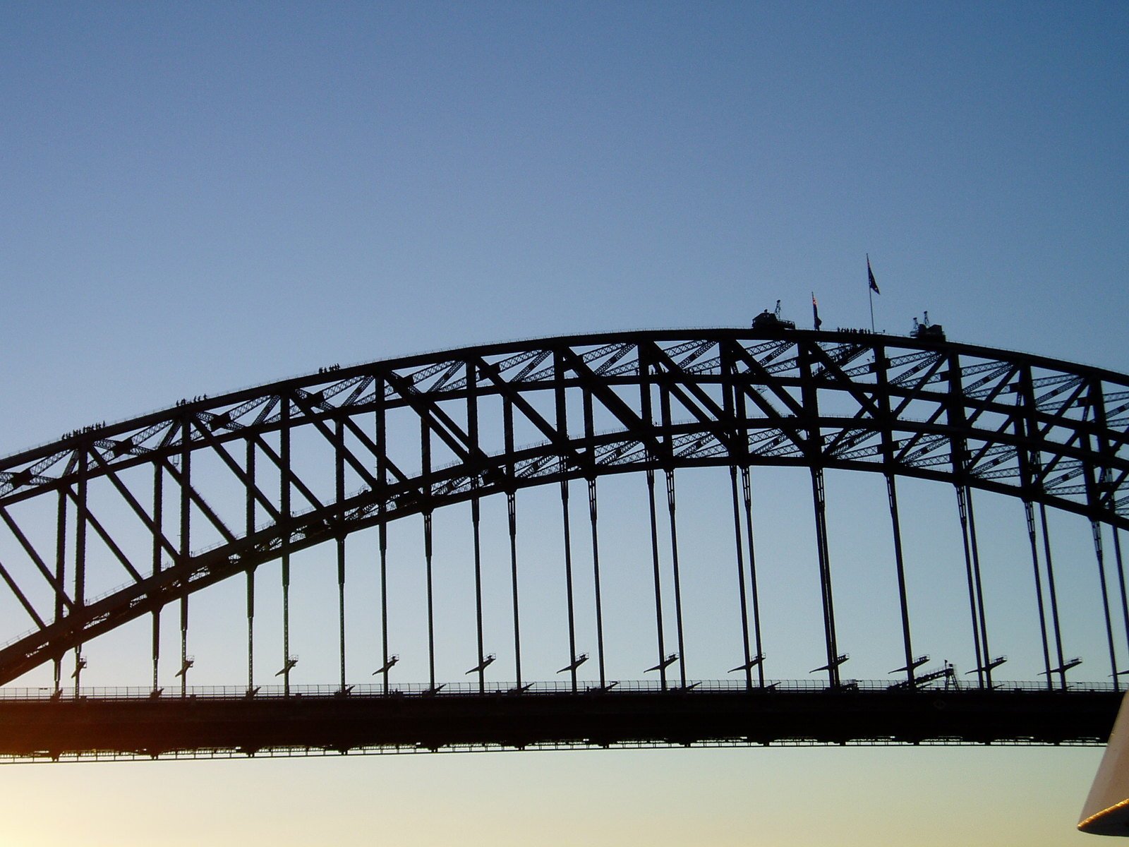 an airplane flying in the sky over the bridge