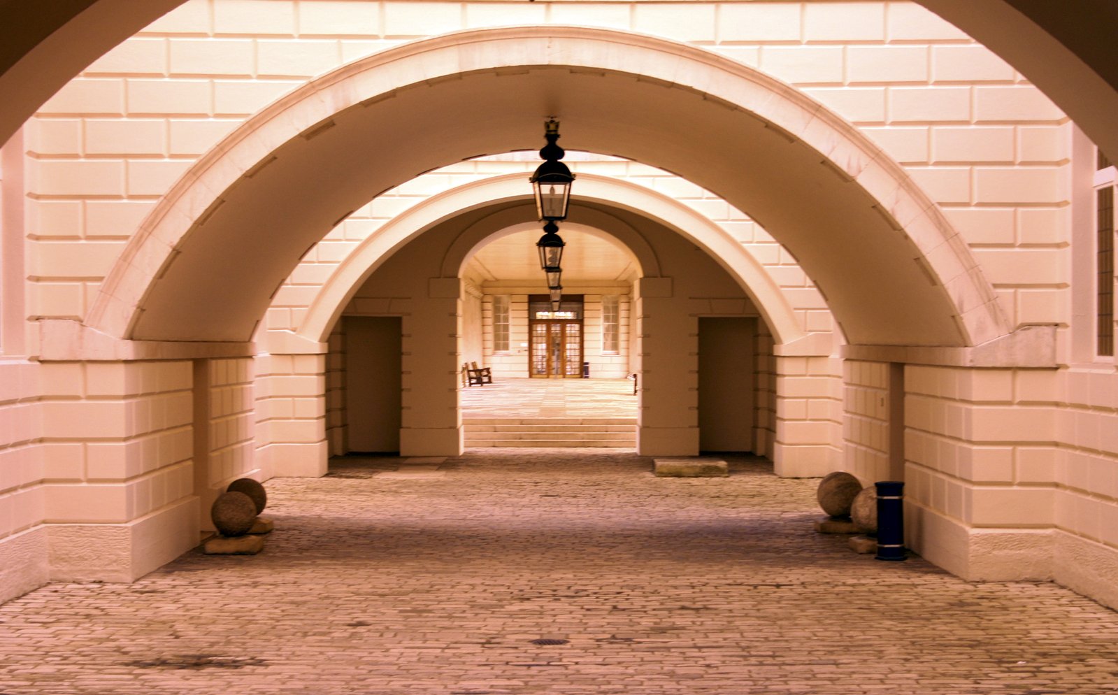 archways with lampposts line the walkway inside a building