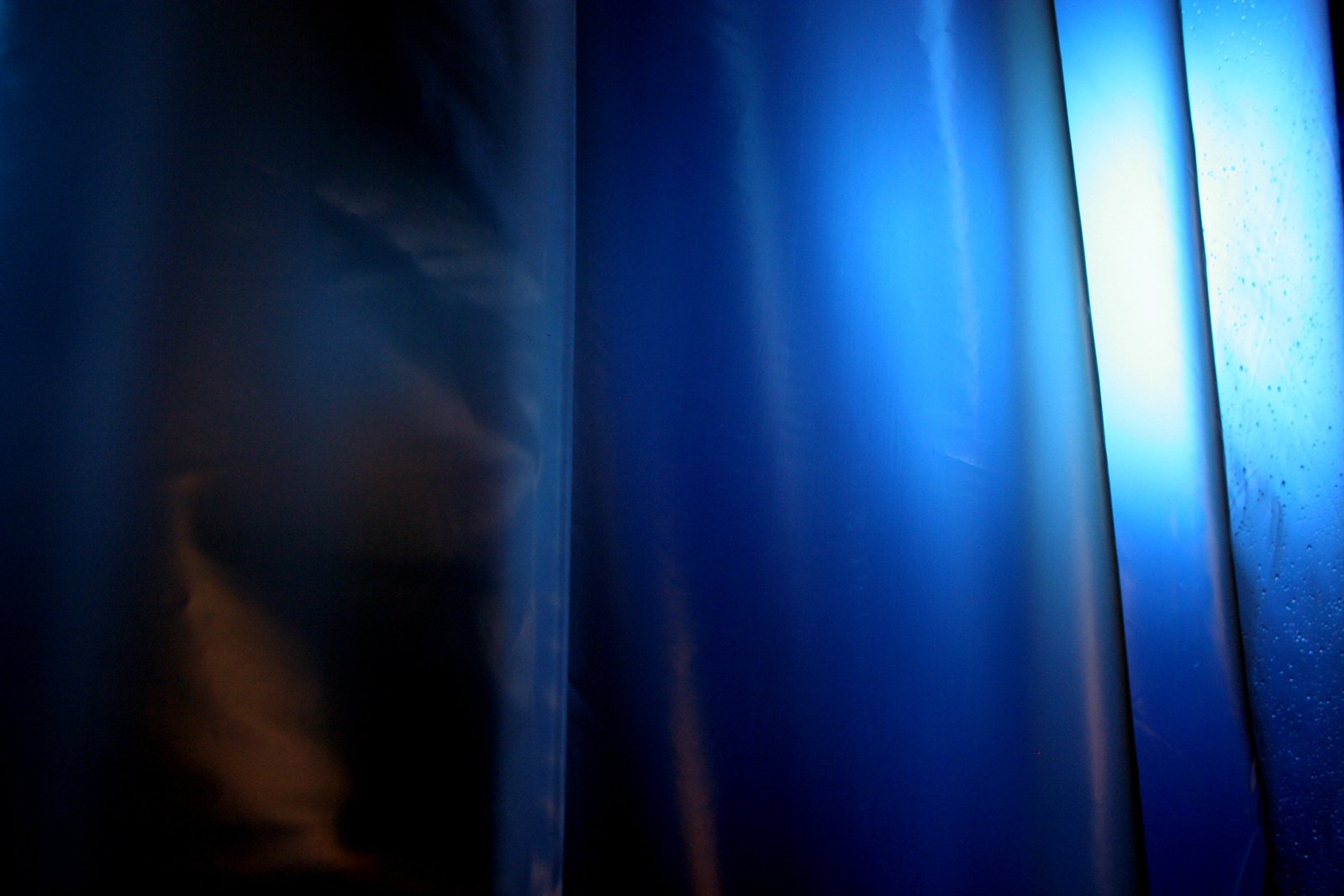 some blue curtained curtains lit up in the dark