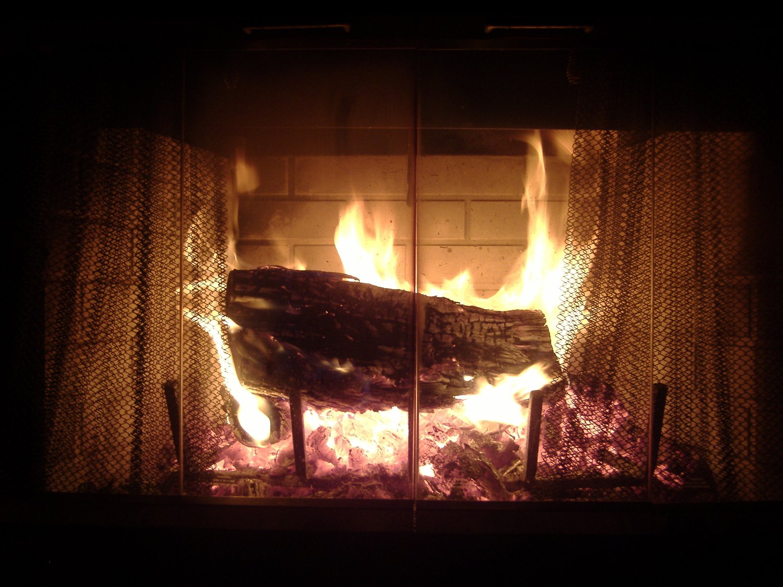 an open fire is lit by a curtain