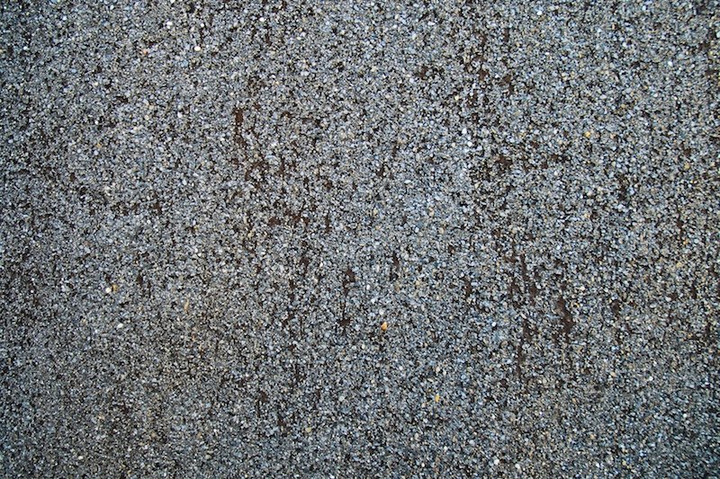 a grungy gray concrete textured with white, brown and black paint