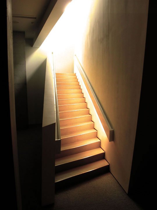 a stair case with a light coming through the side