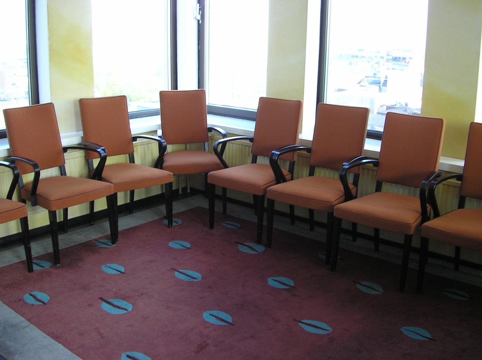six chairs arranged up facing a large window
