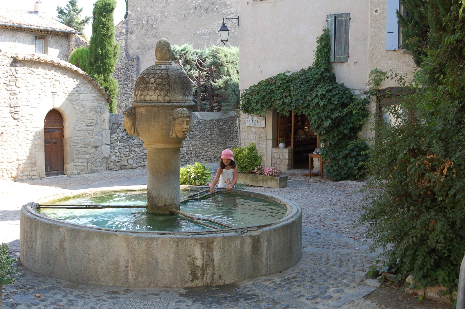 a fountain with a girl in a pink hat