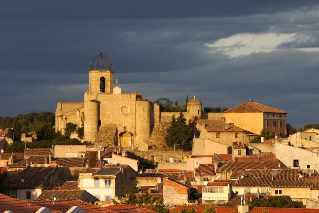 a small medieval town is shown with dark clouds
